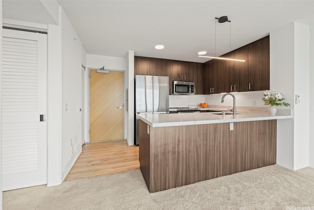 615 Keawe St Unit 3005, Honolulu, HI 96813 - kitchen featuring stainless steel appliances, light carpet, light countertops, a peninsula, and dark brown cabinetry