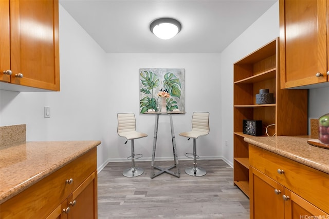 520 Lunalilo Home Rd Unit 6419, Honolulu, HI 96825 - kitchen with open shelves, light wood-style flooring, brown cabinets, and light stone countertops