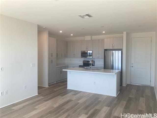 91-1101 Franklin D Roosevelt Ave Unit 365, Kapolei, HI 96707 - kitchen featuring stainless steel appliances, light countertops, wood finished floors, a center island with sink, and recessed lighting