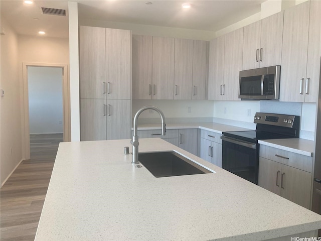 91-1101 Franklin D Roosevelt Ave Unit 365, Kapolei, HI 96707 - kitchen featuring stainless steel appliances, modern cabinets, light brown cabinetry, a center island with sink, and recessed lighting