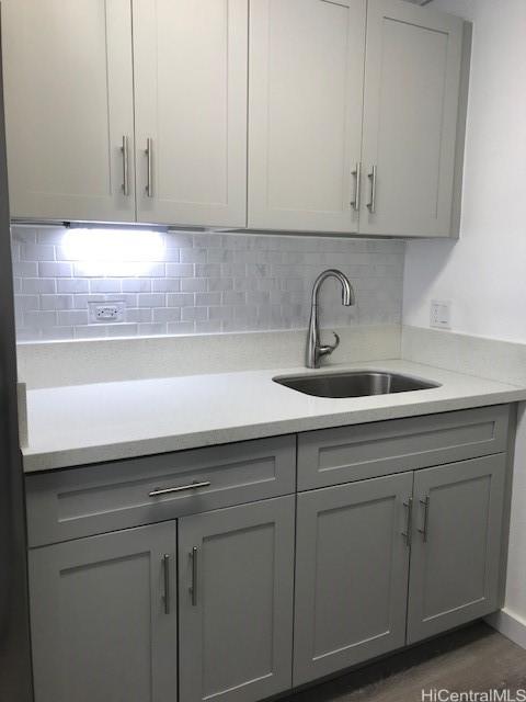 775 Kinalau Pl Unit 1204, Honolulu, HI 96813 - kitchen with gray cabinetry, light countertops, and backsplash