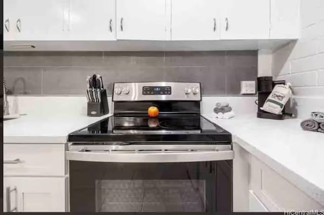 410 Nahua St Unit 204, Honolulu, HI 96815 - kitchen with stainless steel electric stove, light countertops, and white cabinetry