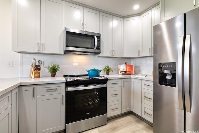 91-497 Kuhialoko St, Ewa Beach, HI 96706 - kitchen featuring stainless steel appliances, tasteful backsplash, light wood-type flooring, and light stone counters