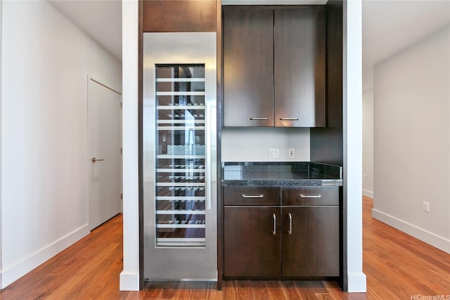 1189 Waimanu St Unit 4301, Honolulu, HI 96814 - kitchen featuring wine cooler, dark brown cabinetry, and wood finished floors