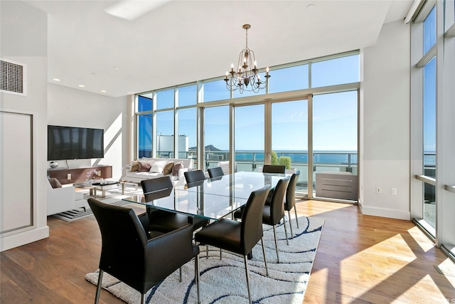 1189 Waimanu St Unit 4301, Honolulu, HI 96814 - dining room with a chandelier, a wall of windows, and wood finished floors