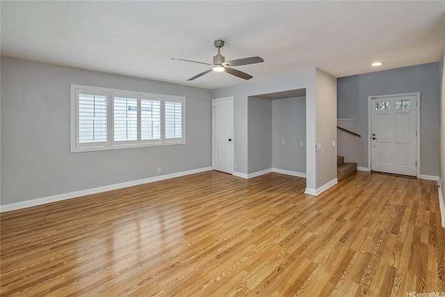 91-324 Kailike Pl, Ewa Beach, HI 96706 - unfurnished living room with stairway, light wood finished floors, and ceiling fan