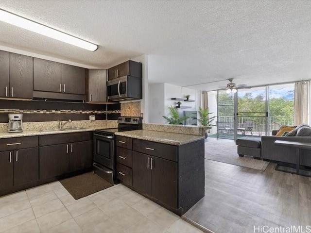 95-2055 Waikalani Pl Unit B404, Mililani, HI 96789 - kitchen featuring open floor plan, a wall of windows, appliances with stainless steel finishes, decorative backsplash, and a peninsula