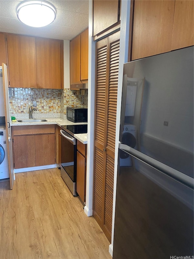 2015 Wilder Ave Unit 3C, Honolulu, HI 96822 - kitchen featuring appliances with stainless steel finishes, light wood-style floors, light countertops, brown cabinetry, and tasteful backsplash