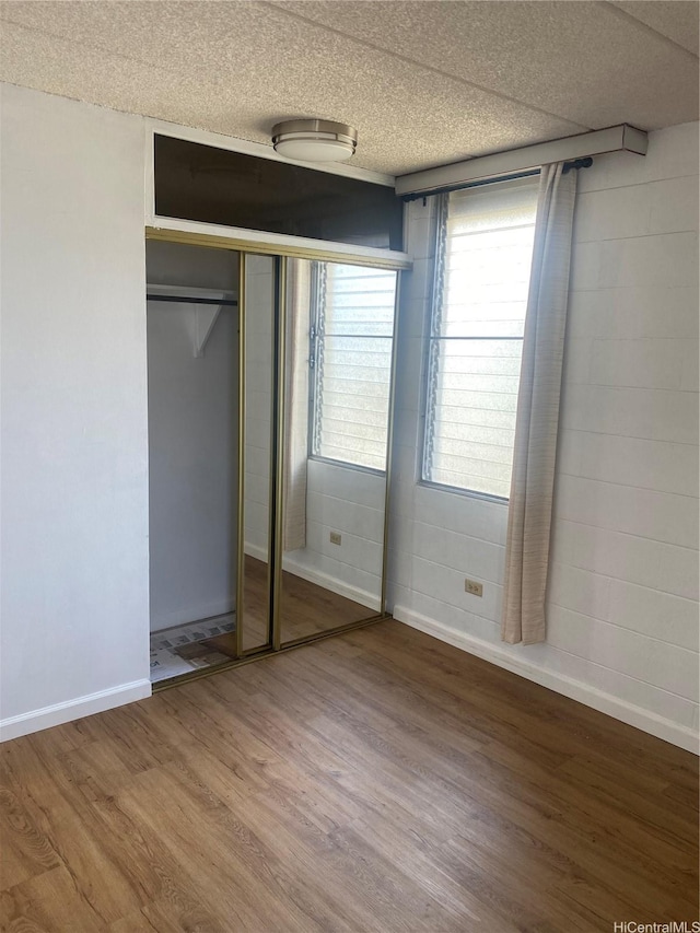 2015 Wilder Ave Unit 3C, Honolulu, HI 96822 - unfurnished bedroom with wood finished floors, a closet, and a textured ceiling