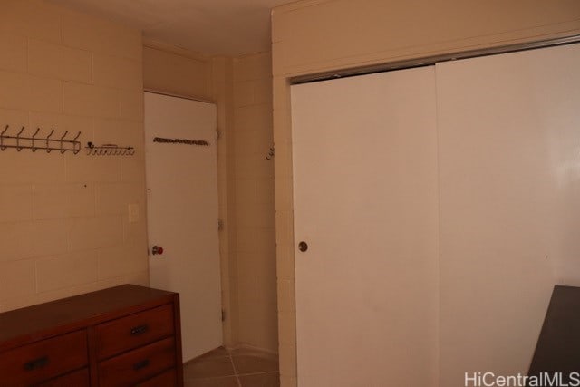 94-245 Leowahine St Unit 3009, Waipahu, HI 96797 - unfurnished bedroom with a closet, concrete block wall, and tile patterned flooring