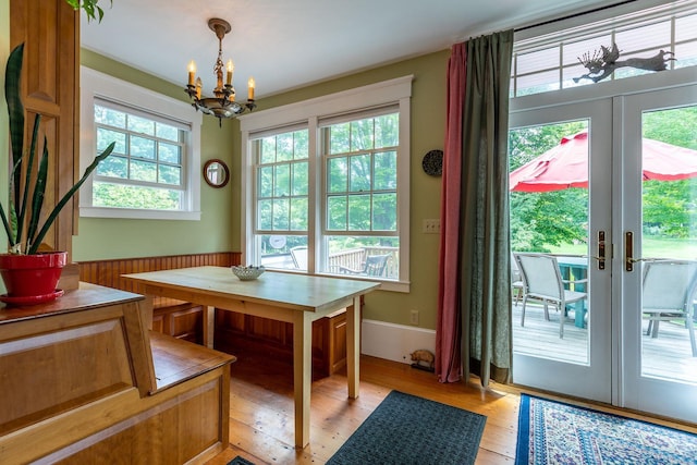 dining room with french doors, an inviting chandelier, light hardwood / wood-style floors, and a wealth of natural light