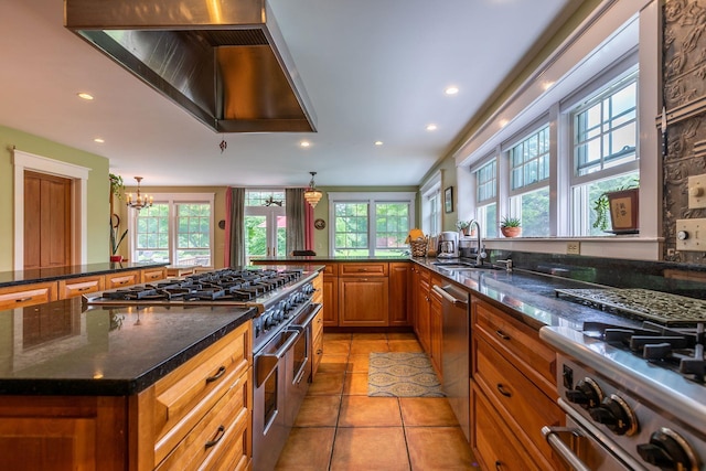 kitchen featuring an inviting chandelier, hanging light fixtures, a healthy amount of sunlight, and stainless steel appliances