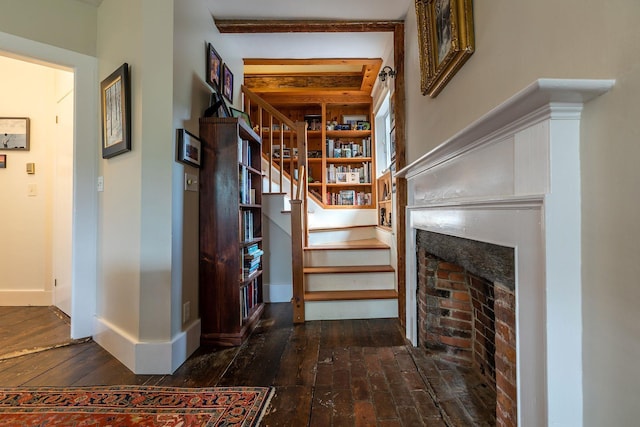 stairway featuring dark wood-type flooring and a fireplace