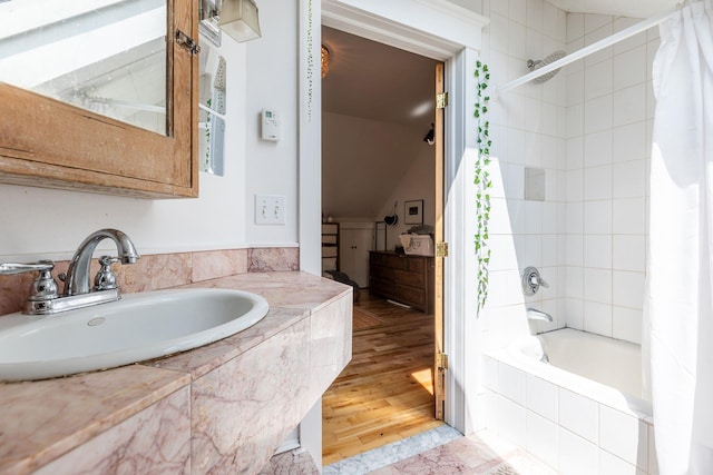 bathroom with sink, hardwood / wood-style flooring, and shower / tub combo