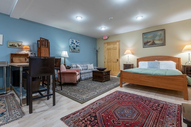 bedroom featuring beam ceiling and light hardwood / wood-style floors