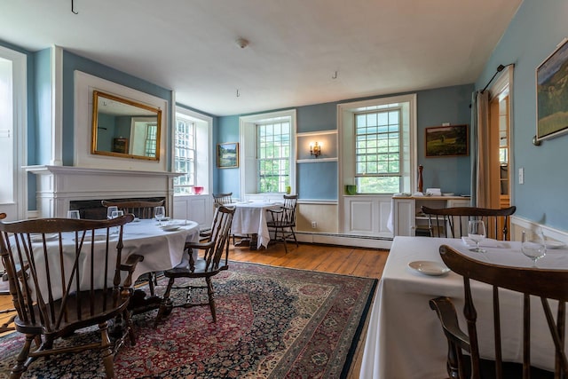 dining room featuring a baseboard heating unit and light wood-type flooring