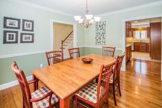 dining area with an inviting chandelier, crown molding, and light tile flooring