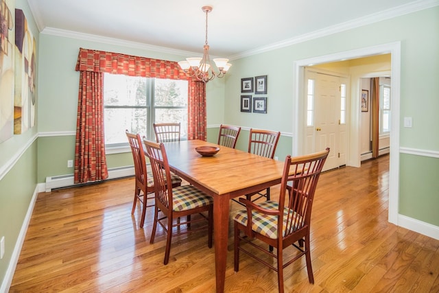 dining space with ornamental molding, a baseboard radiator, light wood-type flooring, and an inviting chandelier