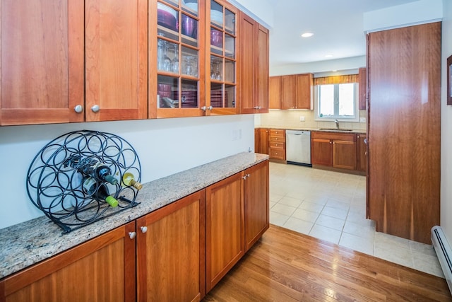 kitchen with light stone countertops, backsplash, sink, light tile floors, and stainless steel dishwasher