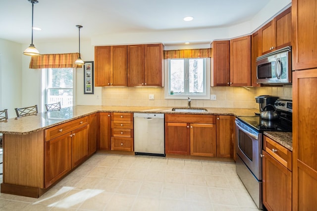 kitchen with light tile flooring, light stone countertops, appliances with stainless steel finishes, and sink