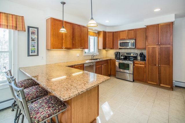 kitchen with kitchen peninsula, backsplash, a kitchen bar, stainless steel appliances, and pendant lighting