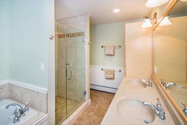 bathroom featuring vanity with extensive cabinet space, plus walk in shower, dual sinks, tile flooring, and baseboard heating