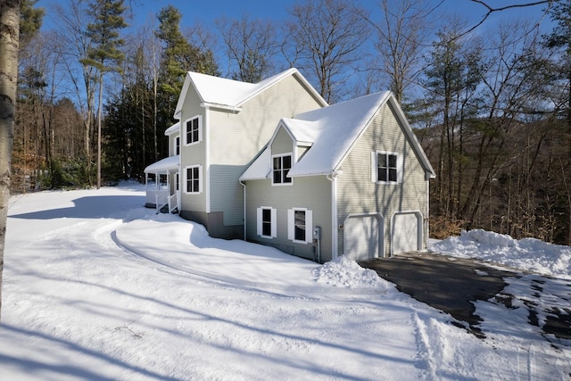 view of snow covered exterior featuring a garage