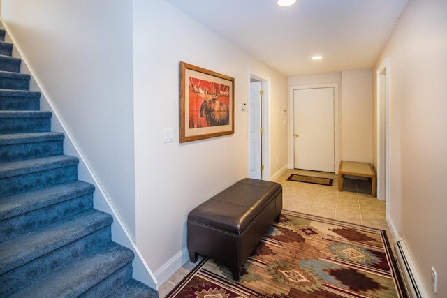 hall featuring light tile flooring and baseboard heating