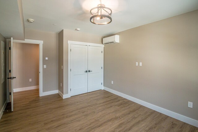 243 Skimobile Rd Unit 354, Conway, NH 03860 - unfurnished bedroom with hardwood / wood-style floors, a closet, and a wall mounted air conditioner