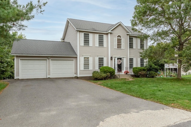 colonial inspired home featuring a front yard and a garage