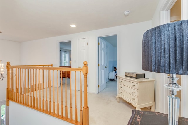 hallway featuring an inviting chandelier, light carpet, and a healthy amount of sunlight