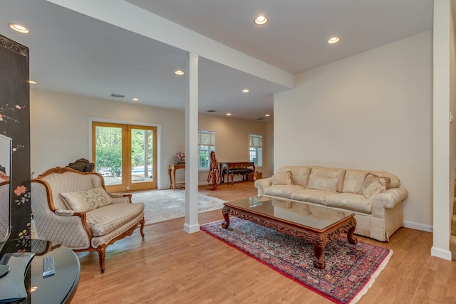 living room featuring decorative columns and light hardwood / wood-style floors