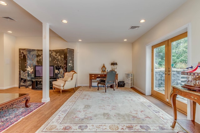 living area with light hardwood / wood-style floors and french doors