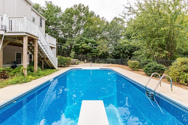 view of pool with a deck and a diving board