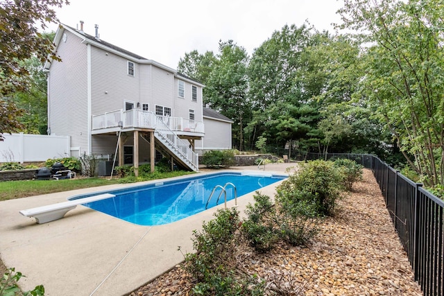 view of pool featuring a diving board, a patio area, and a deck