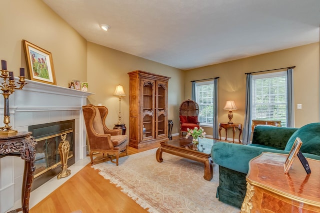 living room featuring a tiled fireplace and light hardwood / wood-style flooring