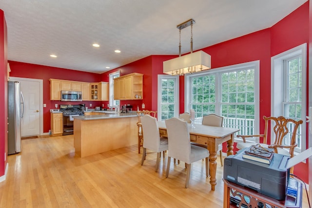 dining space with sink and light wood-type flooring