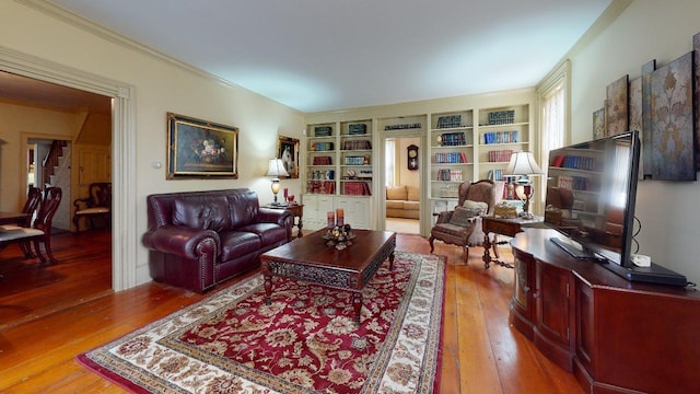 living room with built in shelves and hardwood / wood-style flooring