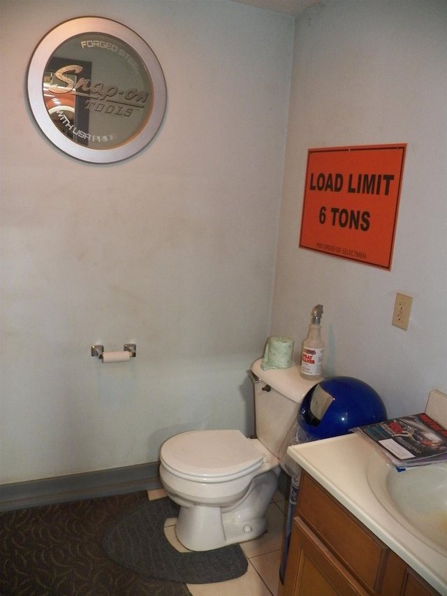 bathroom featuring toilet, tile floors, and vanity