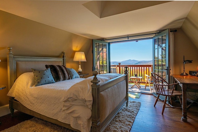 bedroom with vaulted ceiling, a mountain view, and dark hardwood / wood-style flooring