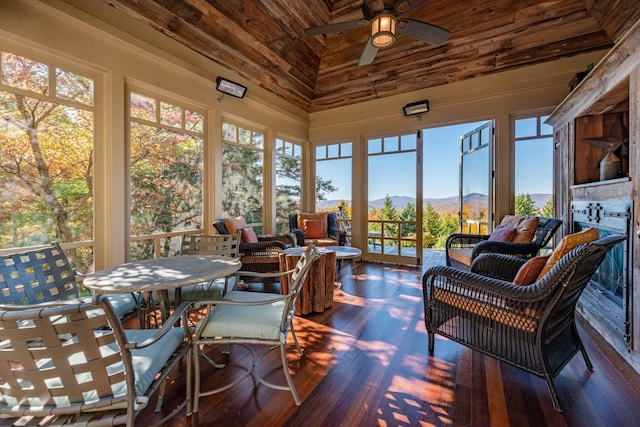 sunroom with vaulted ceiling, wooden ceiling, and ceiling fan