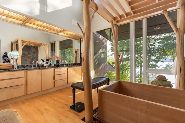 bathroom with a washtub, vanity, and hardwood / wood-style floors