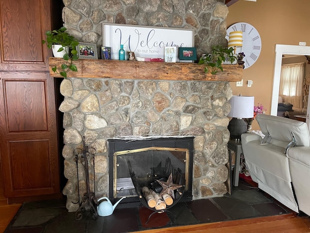 room details featuring a stone fireplace and hardwood / wood-style flooring