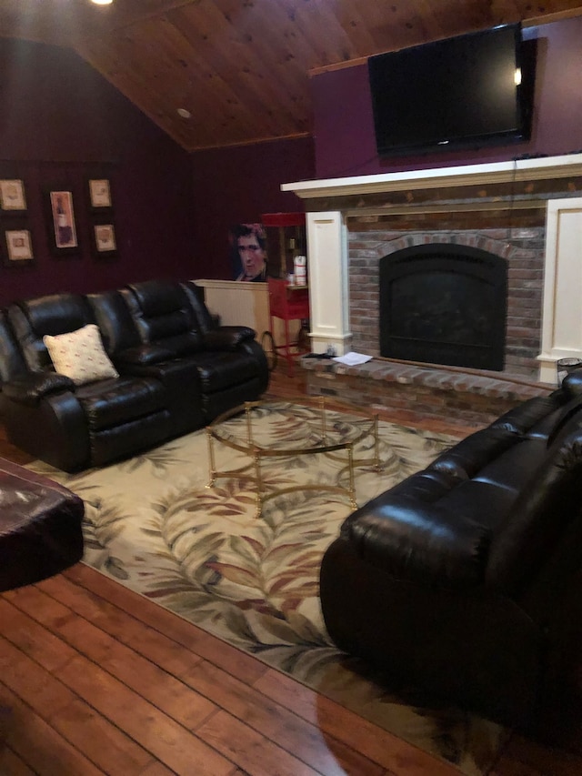 living room with a brick fireplace, hardwood / wood-style floors, wood ceiling, and vaulted ceiling