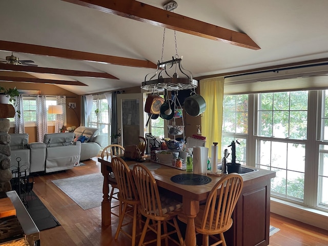 dining room with lofted ceiling with beams, a healthy amount of sunlight, and ceiling fan with notable chandelier