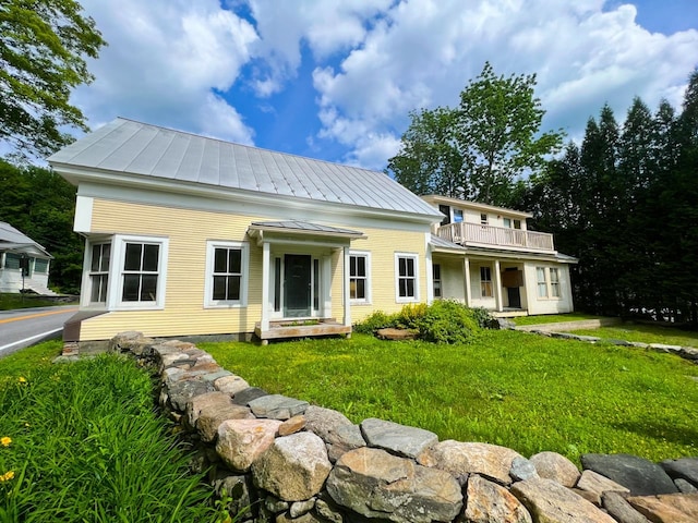 view of front of house featuring a front yard and a balcony