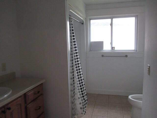 bathroom with vanity, tile flooring, a healthy amount of sunlight, and toilet