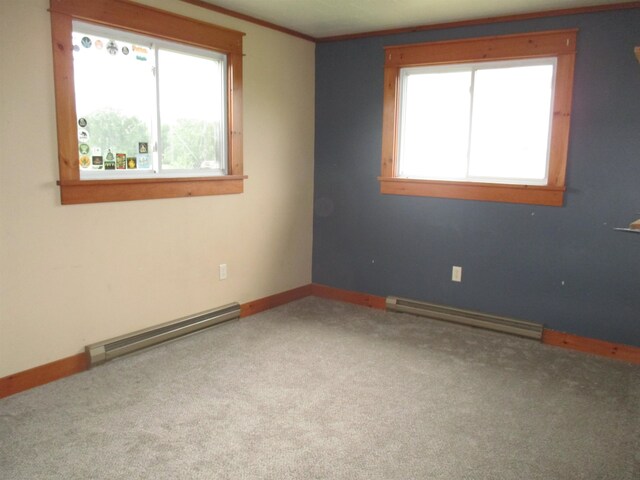 carpeted empty room with plenty of natural light, a baseboard radiator, and crown molding