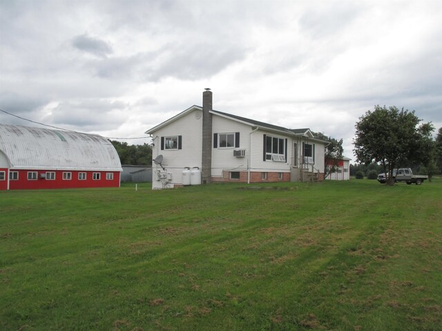 rear view of property with a lawn