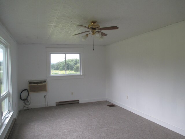 empty room with an AC wall unit, carpet flooring, ceiling fan, and a baseboard heating unit